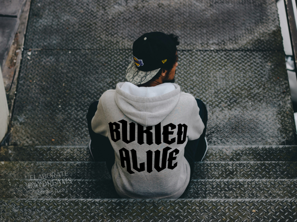 Back view of a person wearing a “Buried Alive” hoodie, designed as fictional merch for a band in L.A. Cannon’s book universe.
